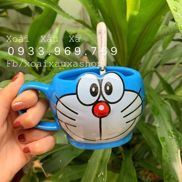 Cốc sứ hình Doraemon kèm muỗng có quai cầm sẽ khiến bạn cảm thấy không khí đầy lạc quan và tiếp thêm năng lượng để bắt đầu một ngày mới. Hãy thưởng thức trà và cà phê yêu thích của bạn trong chiếc cốc đáng yêu này nhé!