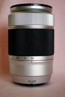 Fujifilm Fuji Fujinon XC 50-230mm F4.5-6.7 OIS II  ซึ่งใช้ชิ้นเลนส์ทั้งหมด 13 ชิ้นใน 10 กลุ่มรวมถึงชิ้นเลนส์แอสเฟอริคัล 1 ชิ้นและชิ้นเลนส์ ED 1 ชิ้น เลนส์นี้แสดงใ