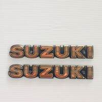 โลโก้ SUZUKI LOGO ตัวอักษรนูน มี 2 สี ตัวอักษรสีทองแดงพื้นดำ / ตัวอักษรสีเงินพื้นสีดำ ขนาด 16 x 2.5 cm. ระยะห่างรูน็อต 10 cm.(ขายเป็นคู่)