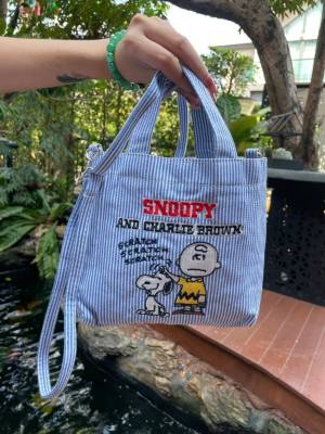 กระเป๋าสะพาย Snoopy Peanuts ทำจากเนื้อผ้าดิบแบบหนา ด้านหน้าเป็นลายปัก สายสามารถถอดและปรับระดับได้  มีช่องเล็กด้านในสำหรับแยกของ ขนาด 22*20*10 cm.
