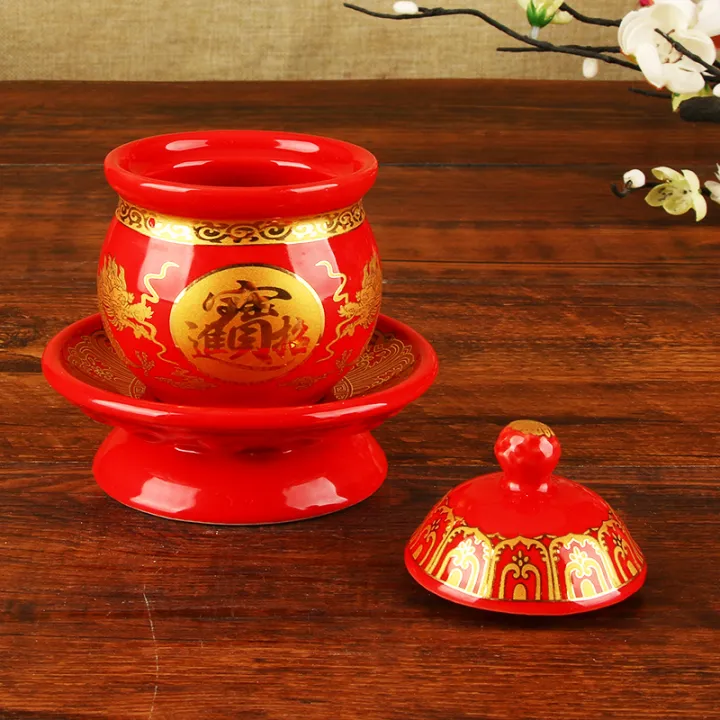 Cup of water supply in front of the ceramic Buddhist temple, offering a ...