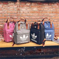 Adidasˉnew อาดิดาสของแบรนด์แฟชันใหม่พิมพ์โลโก้โคลเวอร์กระเป๋าสะพายใส่หนังสือนักเรียนม.ปลายอเนกประสงค์ความจุขนาดใหญ่กระเป๋าสำหรับทั้งหญิงและชายแบบลำลองของชาวอเมริกัน