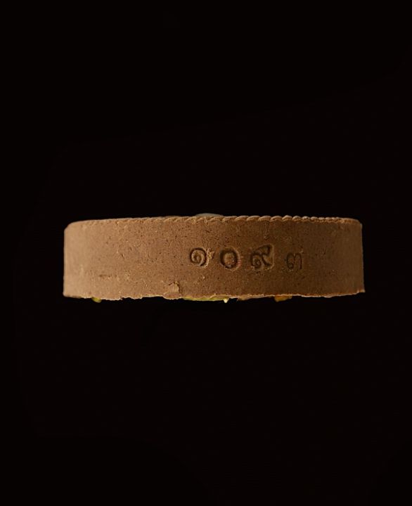 พระผงที่ระลึกงานผูกพัทธสีมา-หลวงปู่บุญพิน-วัดผาเทพนิมิต-ปี2558-เนื้อชานหมากปิดทองหลังฝังตะกรุดเงิน