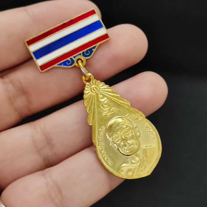 เหรียญของขวัญวันเกิด-เข็มกลัดธงชาติ-หลวงพ่อฤาษีลิงดำ-วัดท่าซุง-ด้านหลังเหรียญเป็นรูปพระเจ้าพรหมมหาราช-อานุภาพครอบจักรวาล